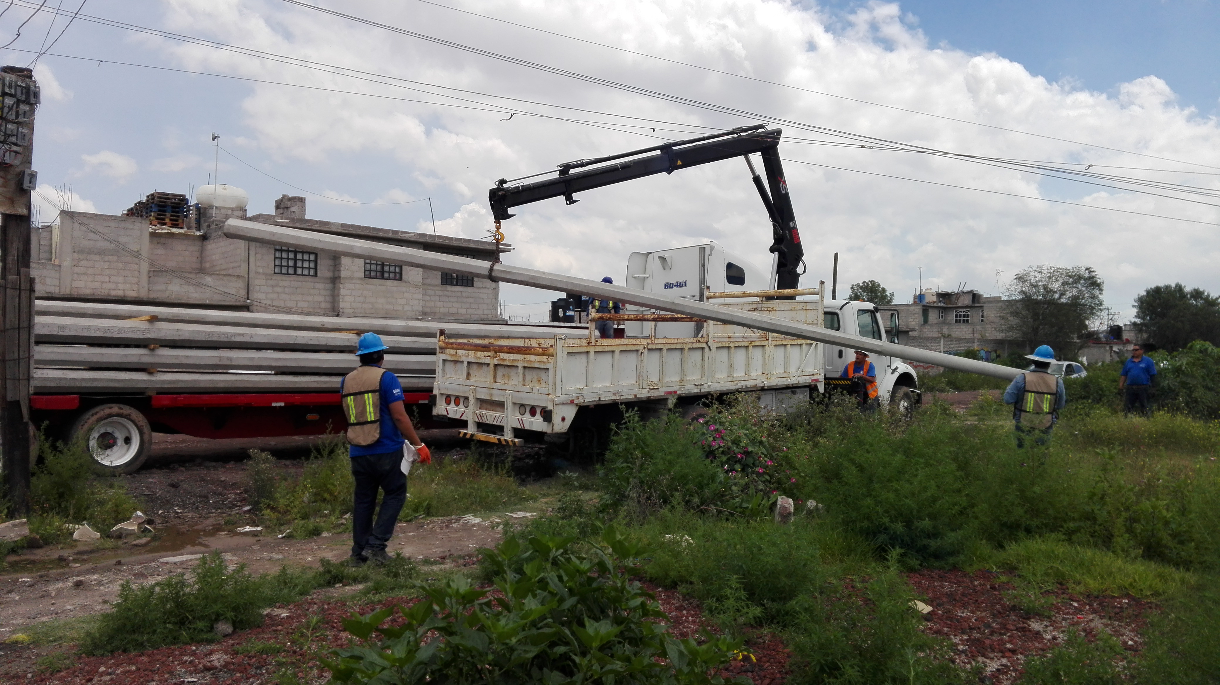 Personal y grúa montando estructuras para infraestructura eléctrica
